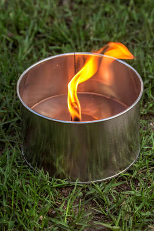 Lighted large aluminum garden candle in summer evening green grassの写真素材