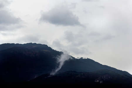 White clouds over mountain on cloudy morningの写真素材