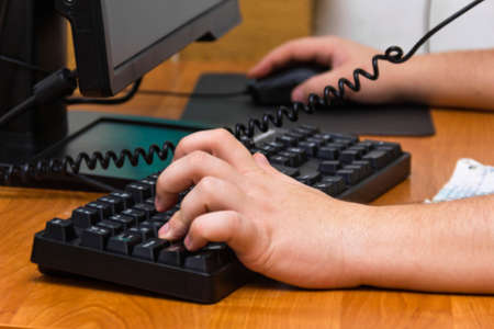 Male hands for computer keyboard in officeの写真素材