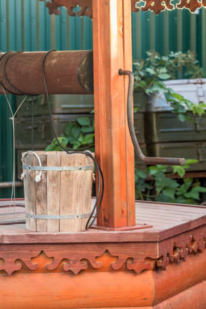 Wooden bucket and well at sunny summer eveningの写真素材