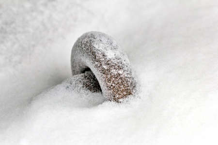 Metal ring under snow at winter day