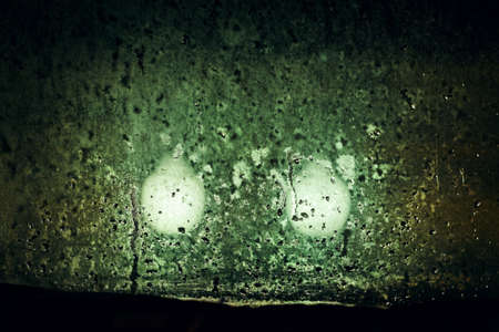 Dim lights outside night window in inclement weatherの写真素材