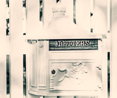 Light mailbox on white fence at sunny weatherの写真素材