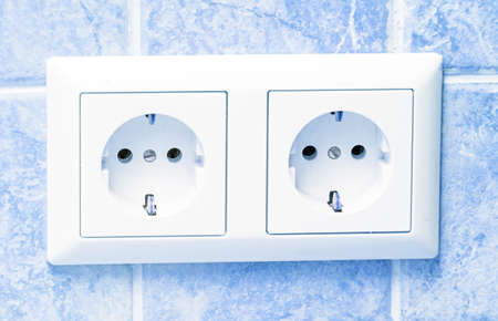 Two white sockets in light blue wall