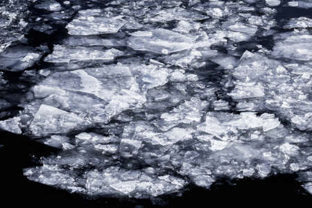 Great ice in dark water in winter cloudy dayの写真素材