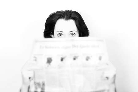 Beauty brunette woman with newspaper in shock in black and white