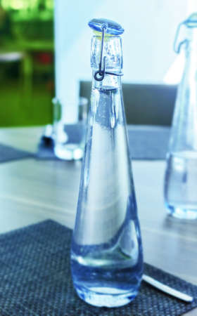 Bottle of blue water on dinner tableの写真素材