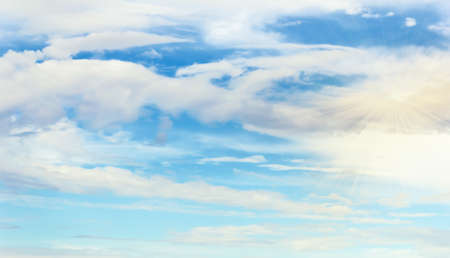 Blue sky with white clouds layered at day with rays of sun