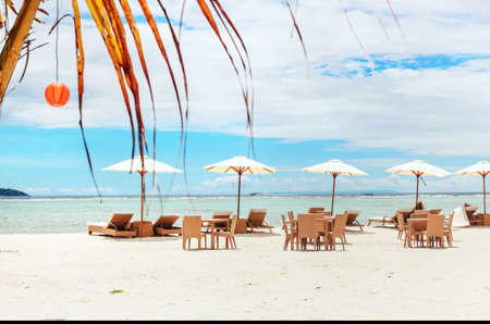 Tables on sandy beach under umbrellas for relaxの写真素材