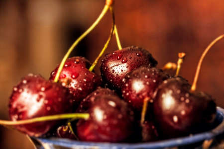 Rpe cherries with drops of water in bowl
