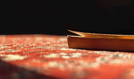 Book is illuminated by sun on red carpetの写真素材