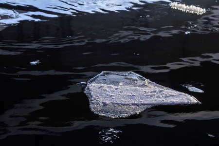 Amazing ice in deep dark water at winter dayの写真素材