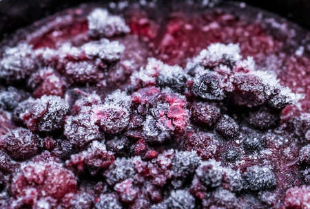 Frozen multi colour berries in frost from freezerの写真素材
