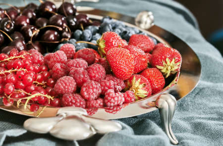 Red ripe fresh berries on silver platterの写真素材