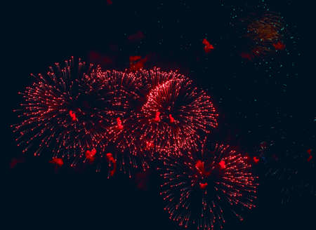 Big red volleys of fireworks in dark sky