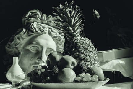 Real still life with fruit and plaster head of Apollo in sepiaの写真素材
