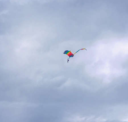 Real skydiver in gray sky with nice original multicolored parachuteの写真素材