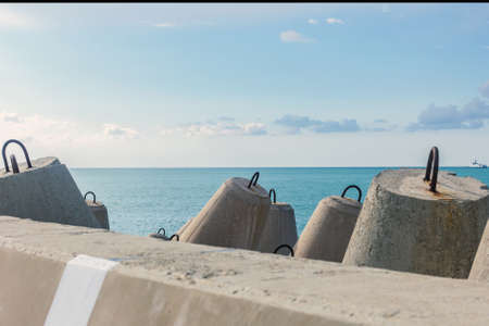 Real strong breakwaters on sea pier at day sunny weatherの写真素材
