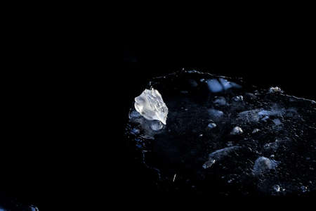 Real light piece of ice on dark water at cool winter dayの写真素材