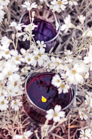 Real red wine and white flowers for romantic best atmosphereの写真素材