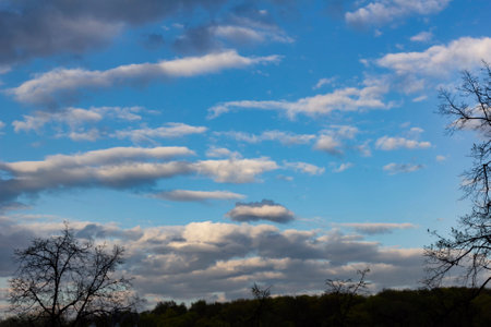 Real white cumulus clouds in blue sky on clear spring evening