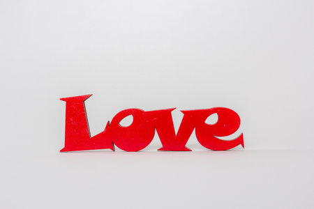 Love word made from red wood on white background. St Valentine's or Mothers Day greeting card. Wedding invitation conceptの写真素材