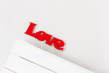 Love word made from red wood on white background. St Valentine's or Mothers Day greeting card. Wedding invitation conceptの写真素材