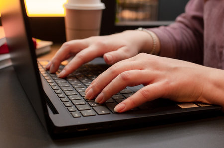 Female hands on keyboard, woman working with a laptop at the table in cafe, girl typing on computer, freelance jobの写真素材