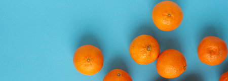 Fresh orange fruits banner with light blue background. Vibrant photo of citrus food top view. Tropical plants with Vitamin Cの写真素材