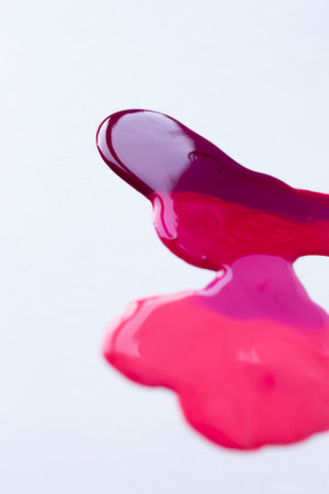 Pink nail polish dripping gradient, close up photo of liquid paint on white backgroundの写真素材