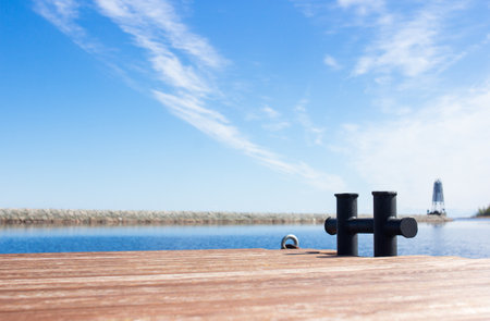 Wooden pier on Ladoga lake on sunny day, nobody on pier, blue water and sky