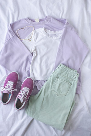 Female trendy clothes flat lay on white sheet background, women set of blue jeans, gray sweatshirt...