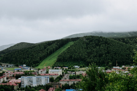 City view from above in Altay mountains, small town rooftops panoramic view, suburbs from bird's eye view, foggy hills, travel in Russiaの写真素材