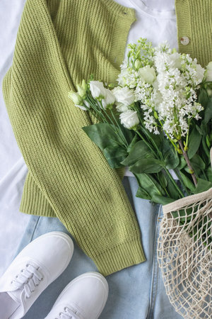 Eco fashion blogger content with clothes flat lay and white flowers