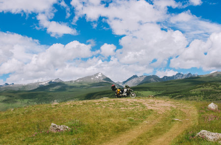 Amazing mountains top view with motorbike in a distance. Moto trip in beautiful landscape. Lifestyle and travel. Active journeyの写真素材