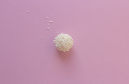 One White Chocolate Candy With Coconut Topping On Pink Background, sweet balls flat lay banner