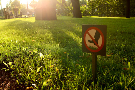 Sign Do not step on green grass in sunlight. Prohibition sign on the lawn. Sign prohibiting walking on the grass in the parkの写真素材