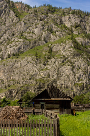 Old wooden houses in peaceful valley in Altay, Russia. Mountain village on vertical shot. Exploration of natureの写真素材