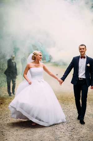 Wedding couple with color smoke in the summer park.の写真素材
