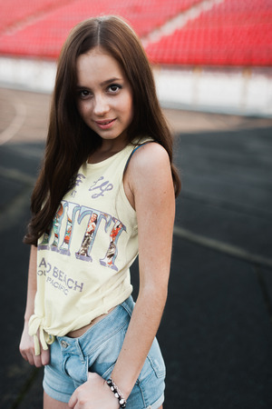 Girl having fun outdoor. Pretty girl sitting at school stadium. Rest from study. Outdoors, Lifestyleの写真素材