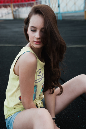 Girl having fun outdoor. Pretty girl sitting at school stadium. Rest from study. Outdoors, Lifestyleの写真素材