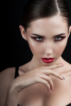 High fashion look.glamor closeup beauty portrait of beautiful Caucasian young woman model with bright makeup with perfect clean skin with colorful red lipの写真素材