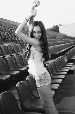 Girl having fun outdoor. Pretty girl sitting at school stadium. Rest from study. Outdoors, Lifestyleの写真素材