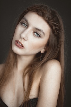 Portrait of beautiful sensual woman with elegant hairstyle. Evening makeup. Girl pigtailed. Fashion photoの写真素材