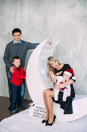 Portrait of friendly family looking at camera on Christmas eveningの写真素材