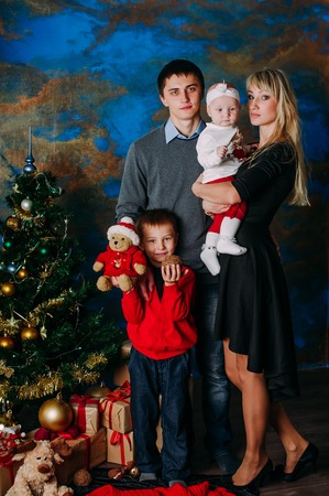 Portrait of friendly family looking at camera on Christmas eveningの写真素材