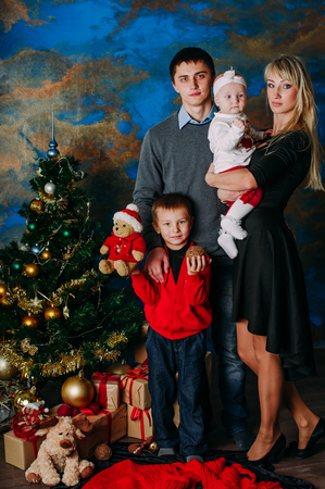 Portrait of friendly family looking at camera on Christmas eveningの写真素材