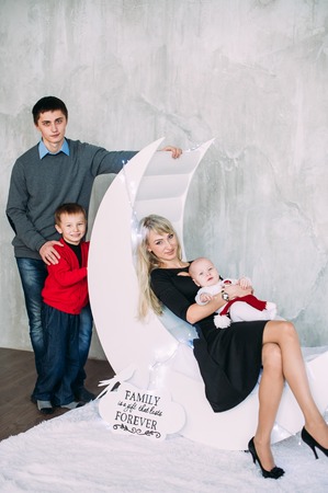 Portrait of friendly family looking at camera on Christmas eveningの写真素材