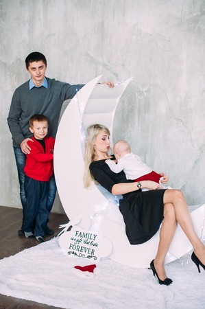 Portrait of friendly family looking at camera on Christmas eveningの写真素材