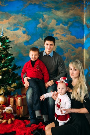 Portrait of friendly family looking at camera on Christmas eveningの写真素材